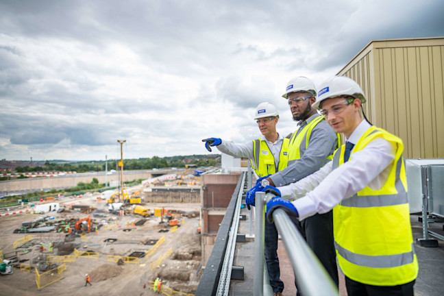 Three construction workers looking over a construction site