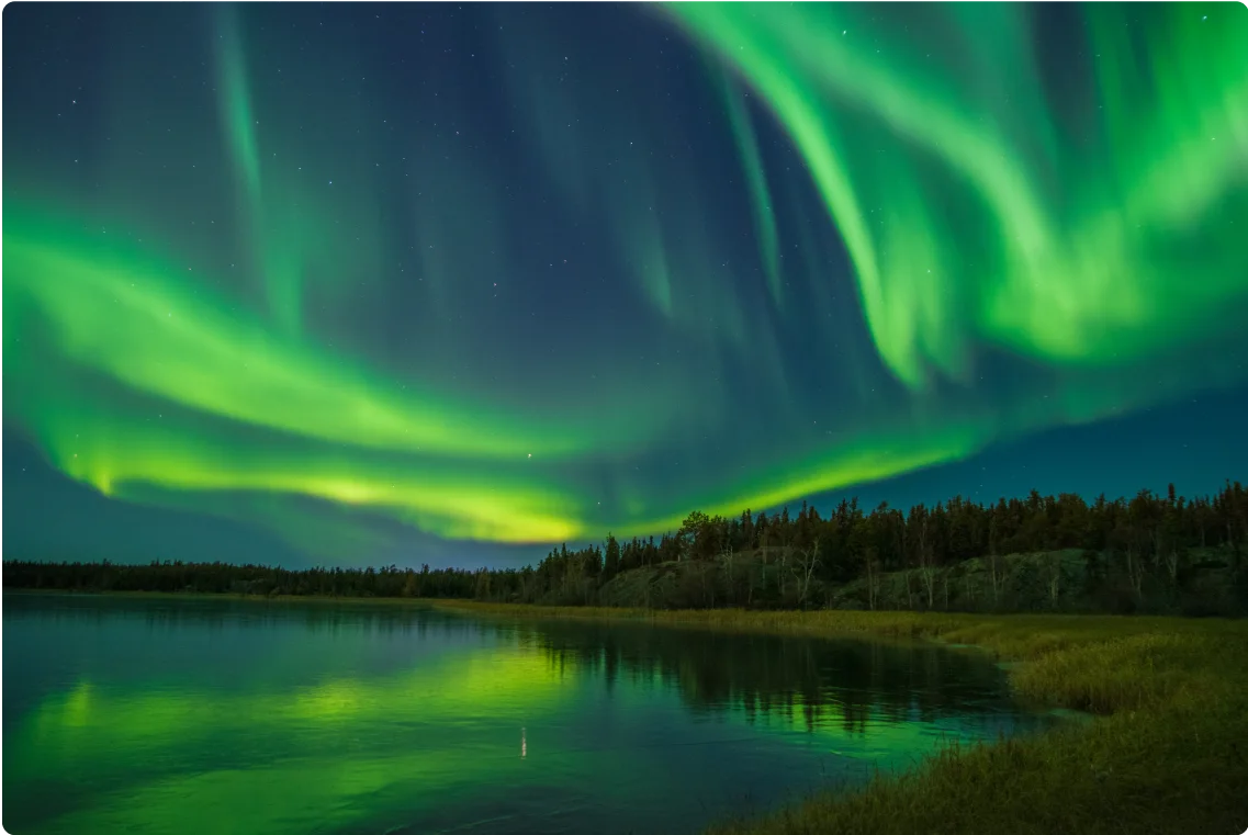 Northern lights on display in a night sky over a bay in Yellowknife