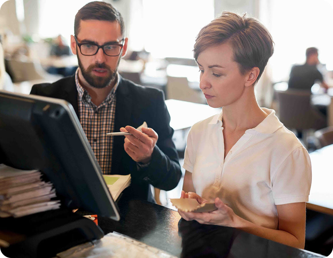 Salesperson using sales enablement insights to review sales data with a restaurant owner 