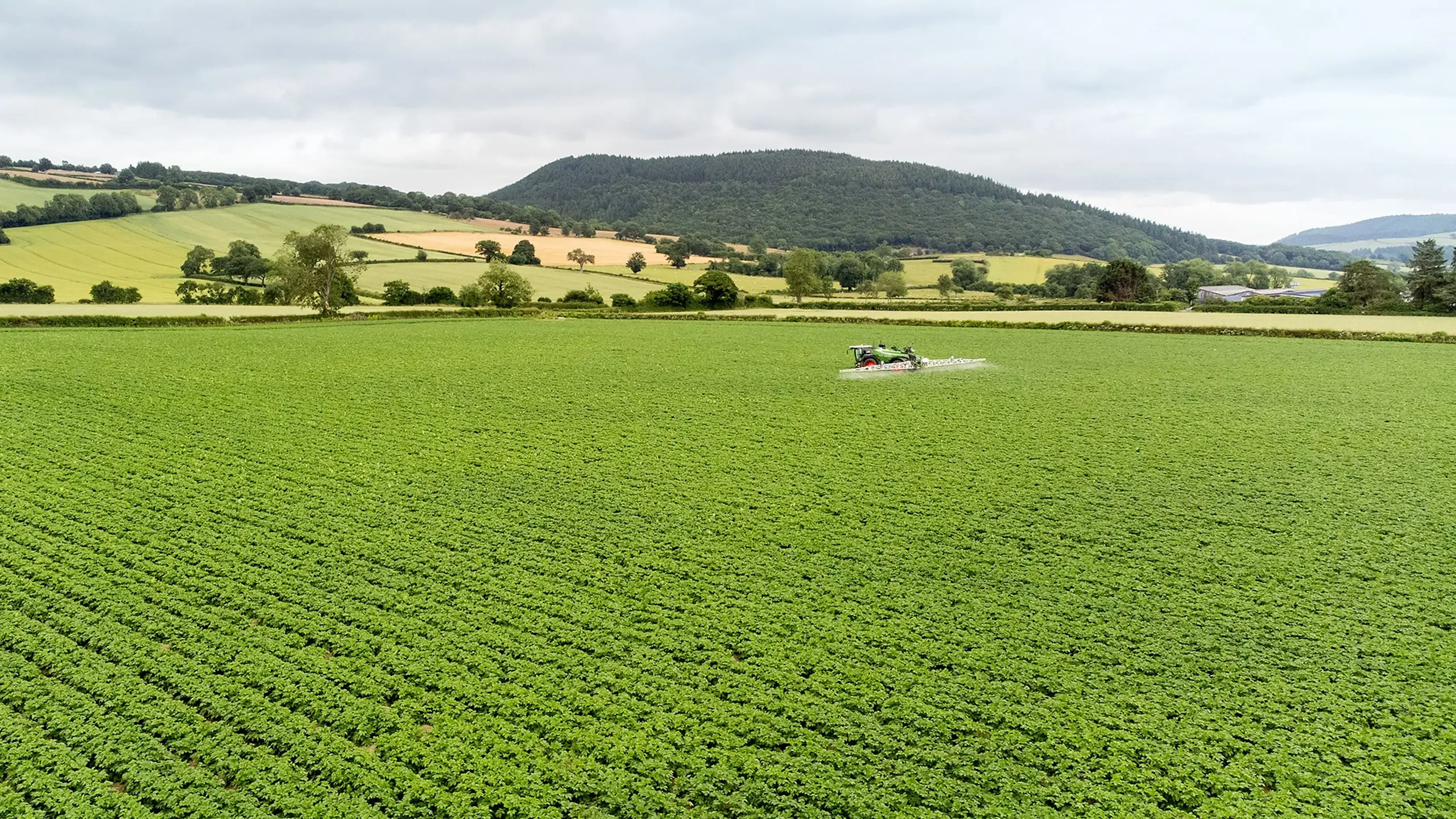 A farm scene featuring a tractor and a map, illustrating crop management and farm management software applications.