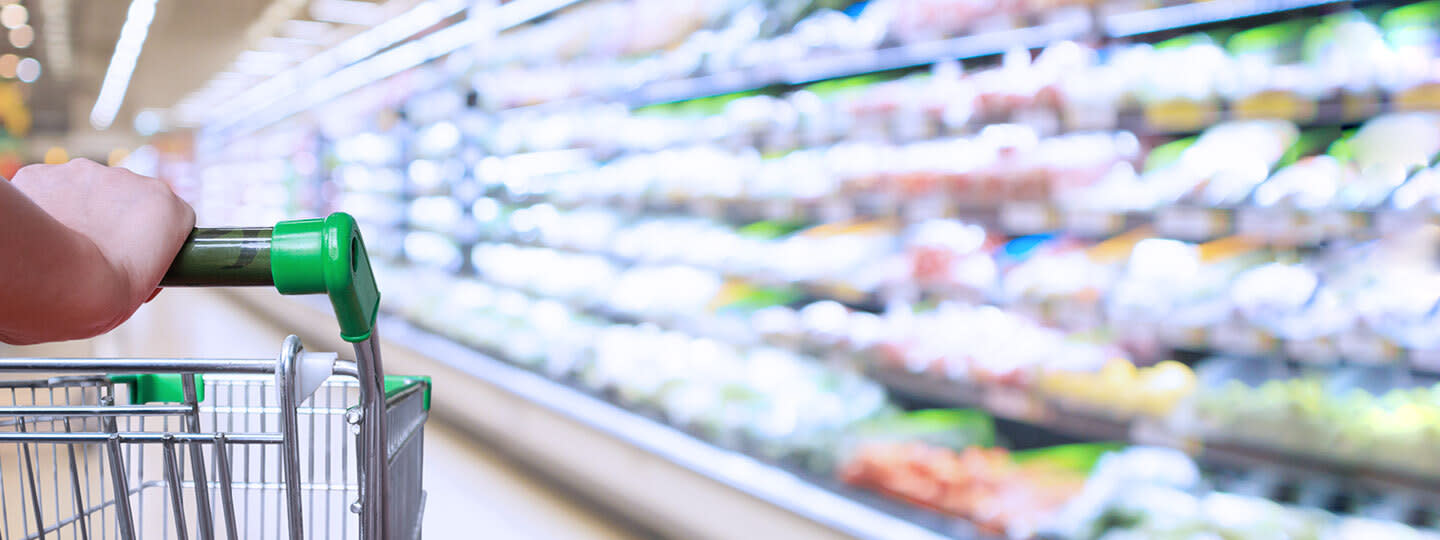 People shopping in a grocery store aisle.
